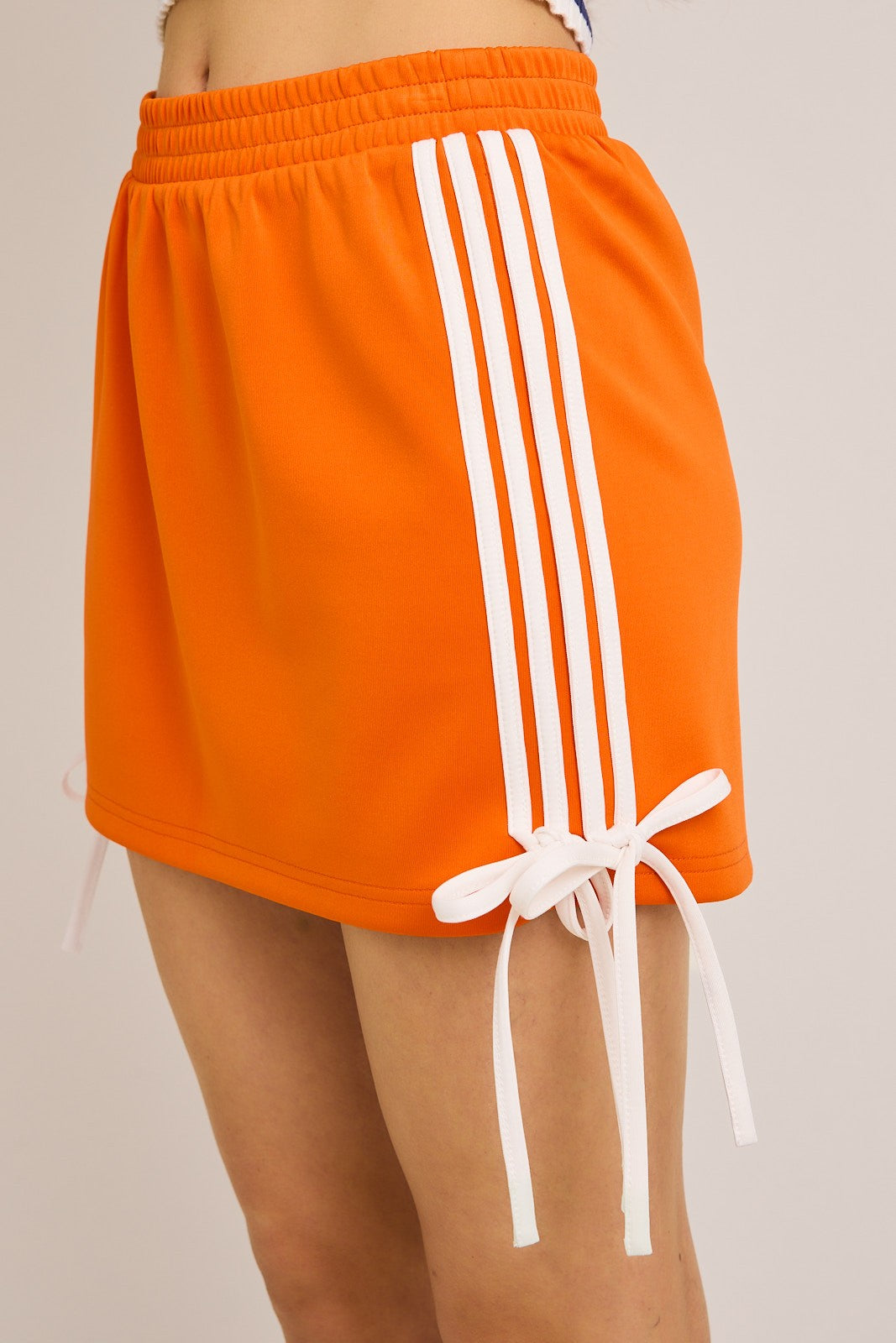 bow detail track mini skirt in orange and white