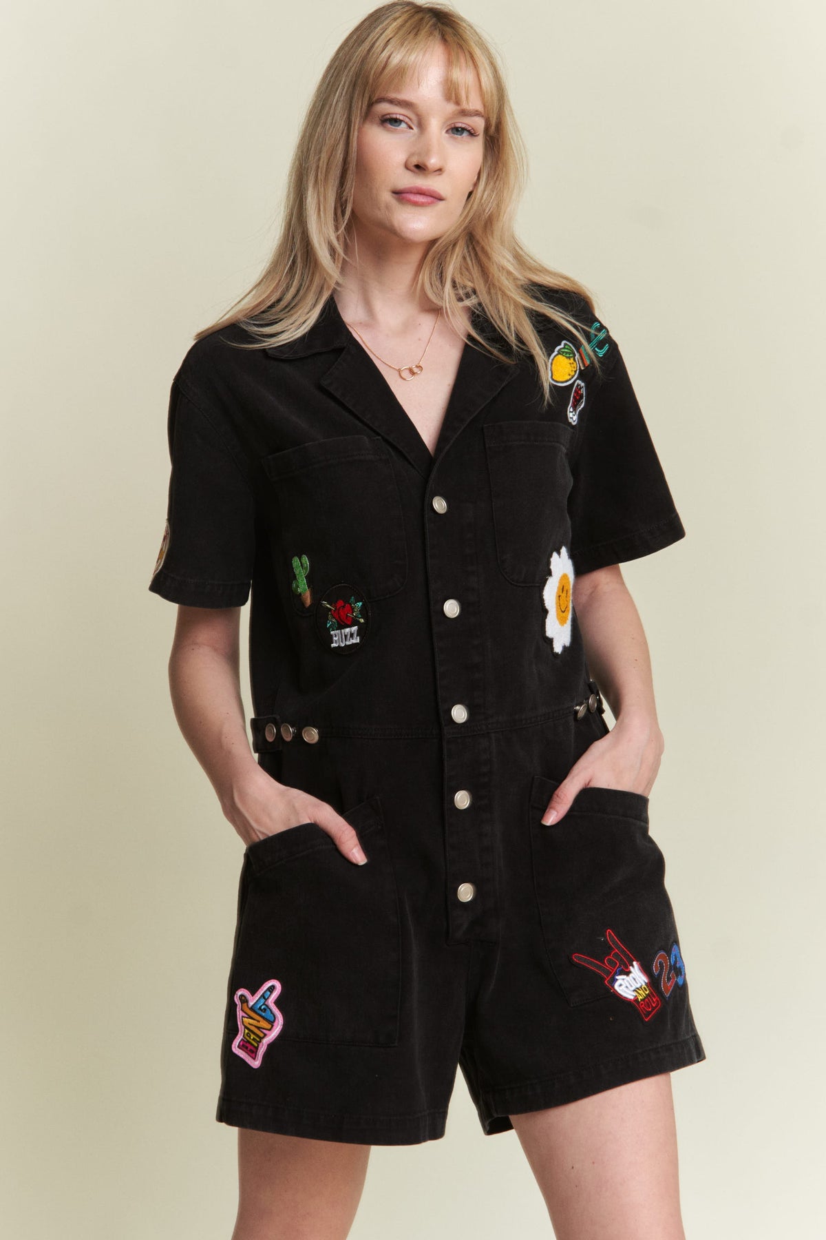 washed black short sleeve button down romper with patches-front