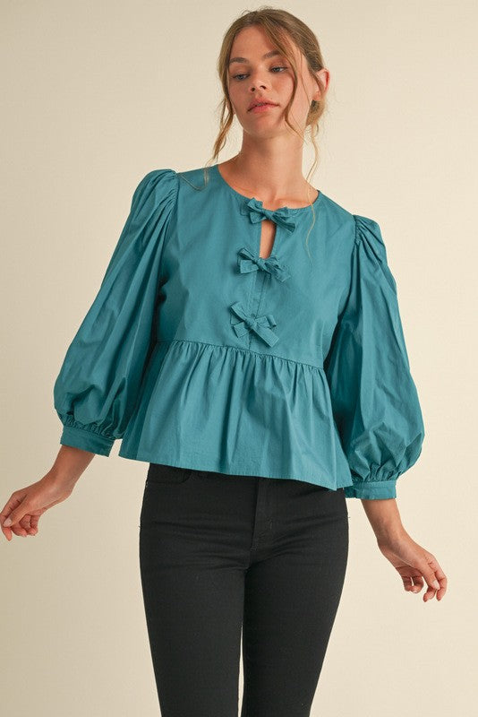 peplum style top with bow details in teal-front