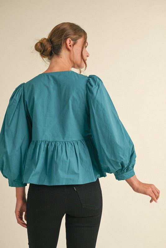 peplum style top with bow details in teal-back