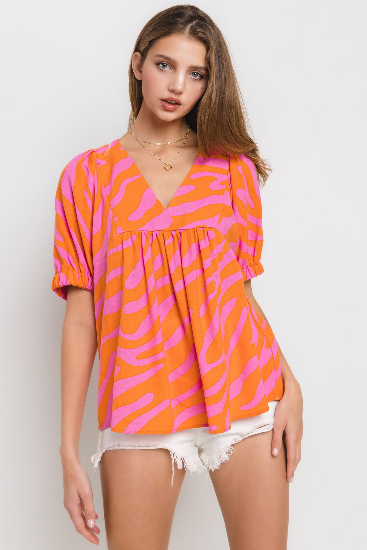 animal print v neck puff sleeve top in orange and pink-front