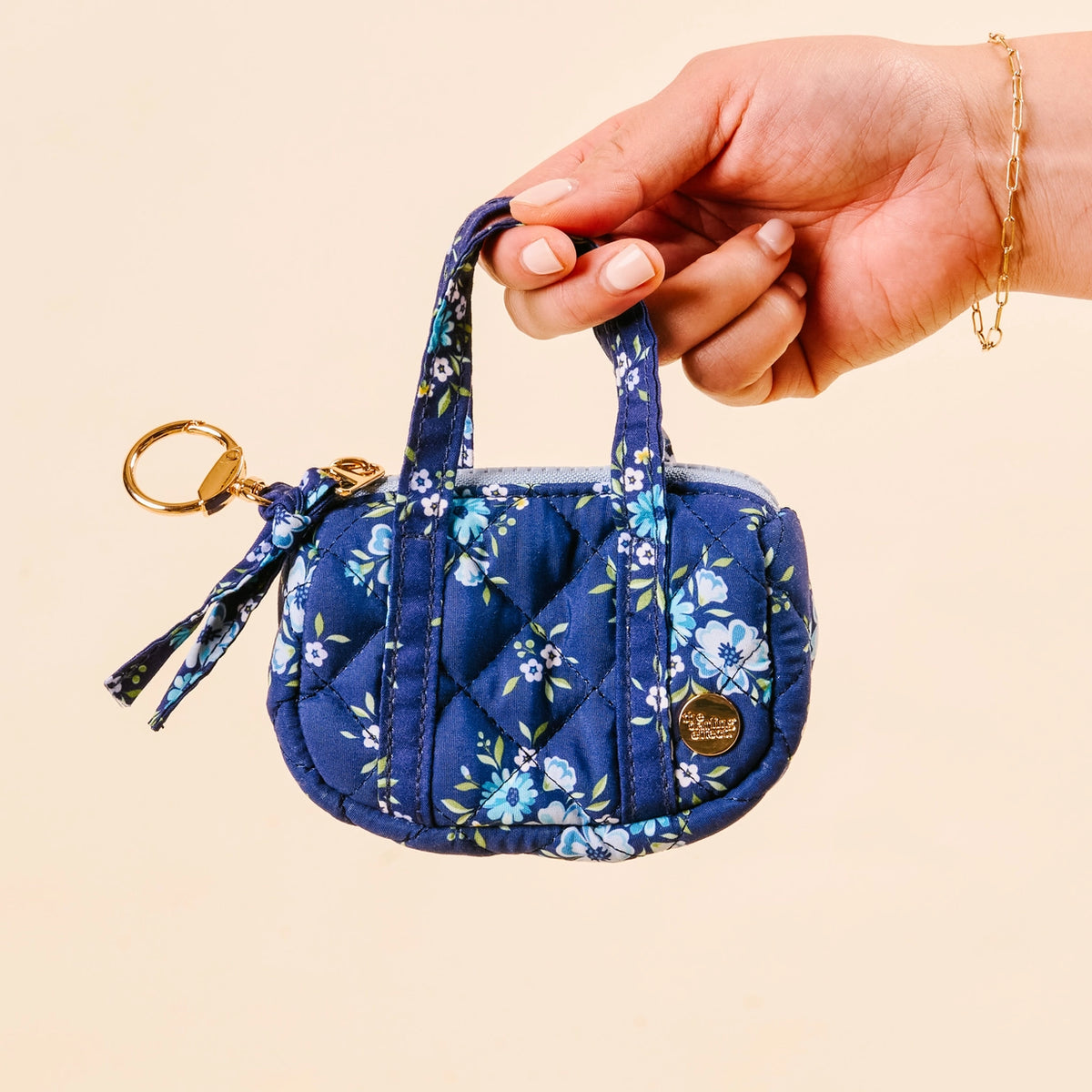 Hand holding Navy Light Blue Purple Floral Mini Duffle Bag Bag Charm on Cream Background Darling Effect Itty Bitty Duffle Bag Charm Endless Daydream Navy