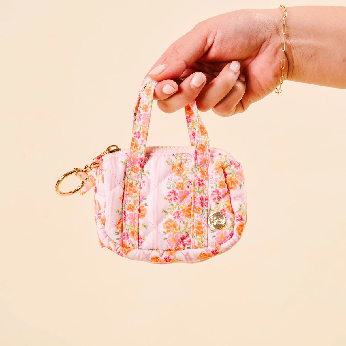 Hand holding Light Pink Orange Hot Pink Floral Mini Duffle Bag Bag Charm on Cream Background Darling Effect Itty Bitty Duffle Bag Charm Petal Parade Pink