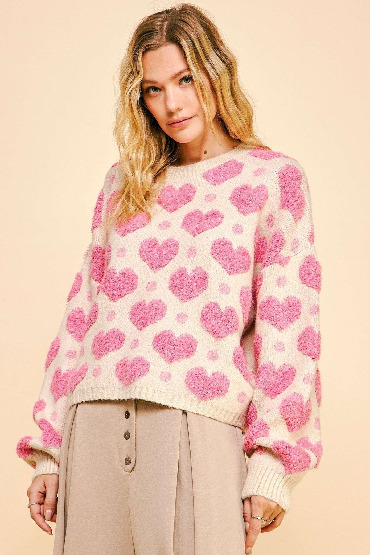 textured heart loose fit long sleeve knit sweater in pink-front