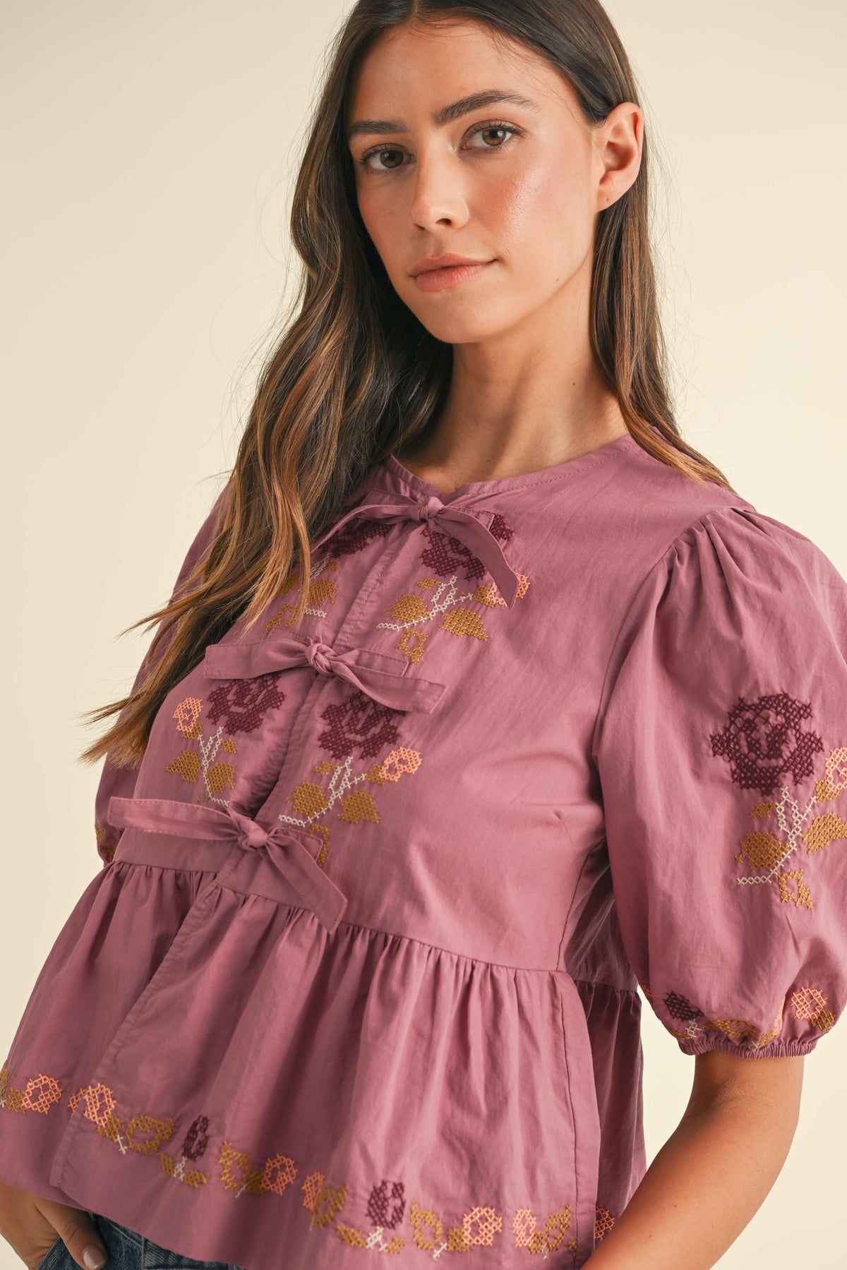 embroidered puff sleeve tie front peplum top in raspberry-front