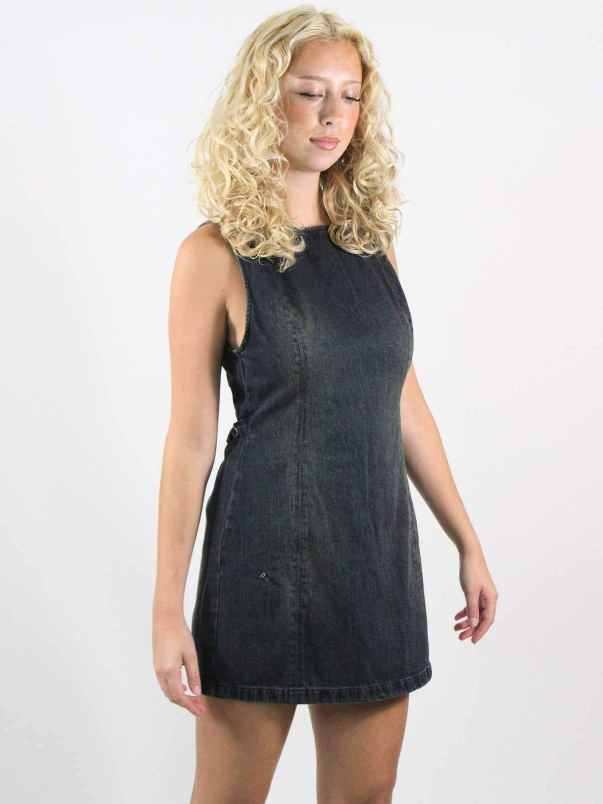 Woman wearing a black sleeveless dress against a white background