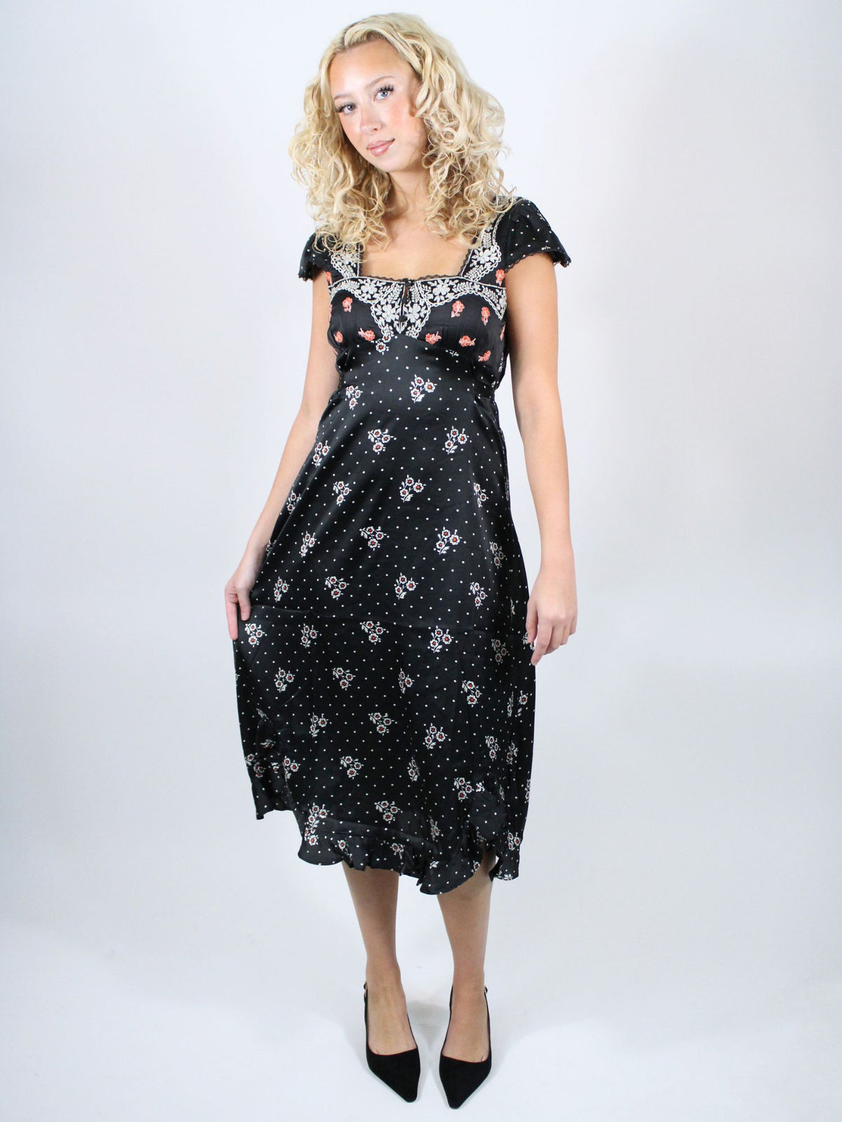 Woman wearing a black dress with white patterns on a white background