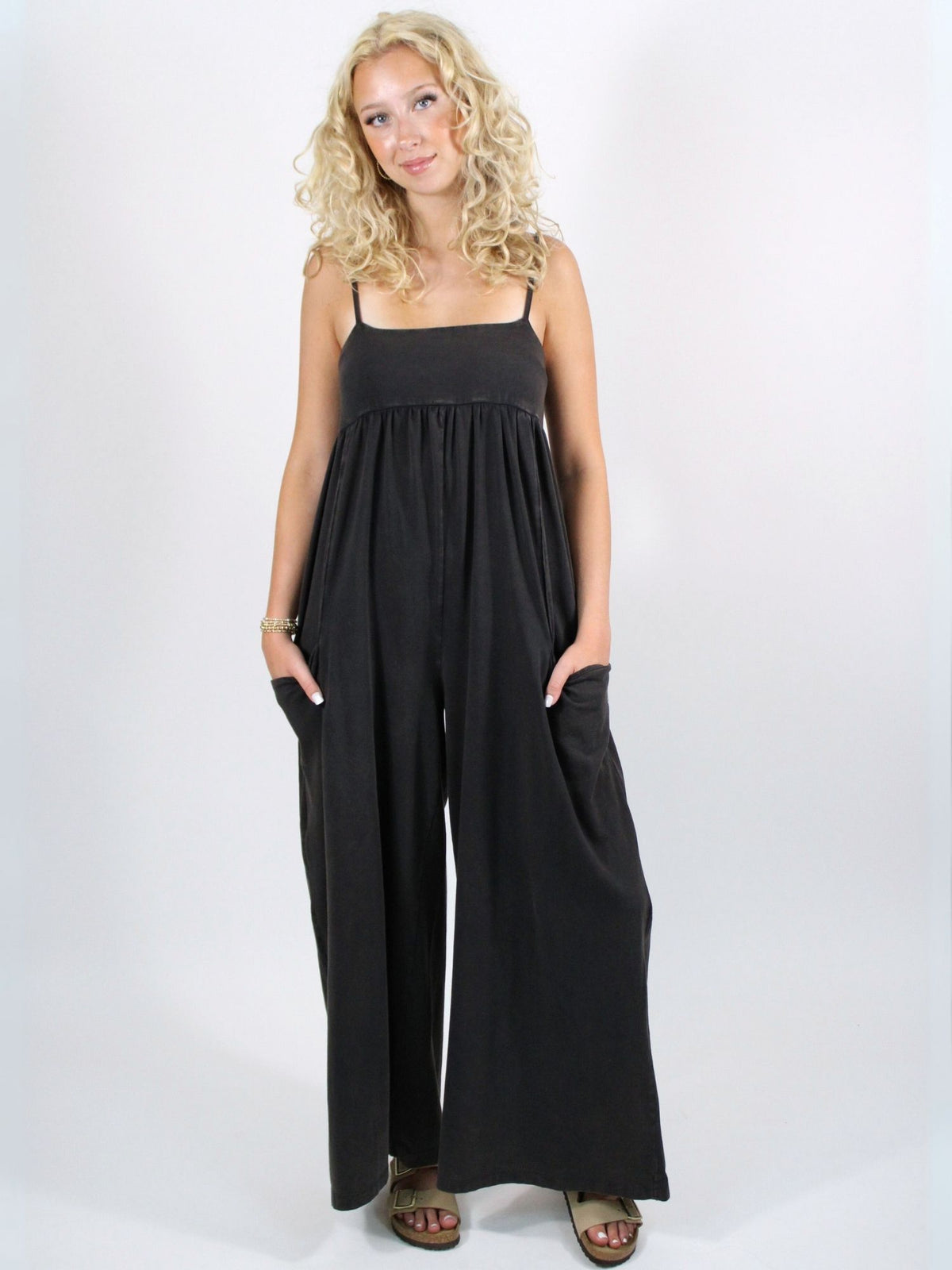 Woman wearing a black jumpsuit on a white background