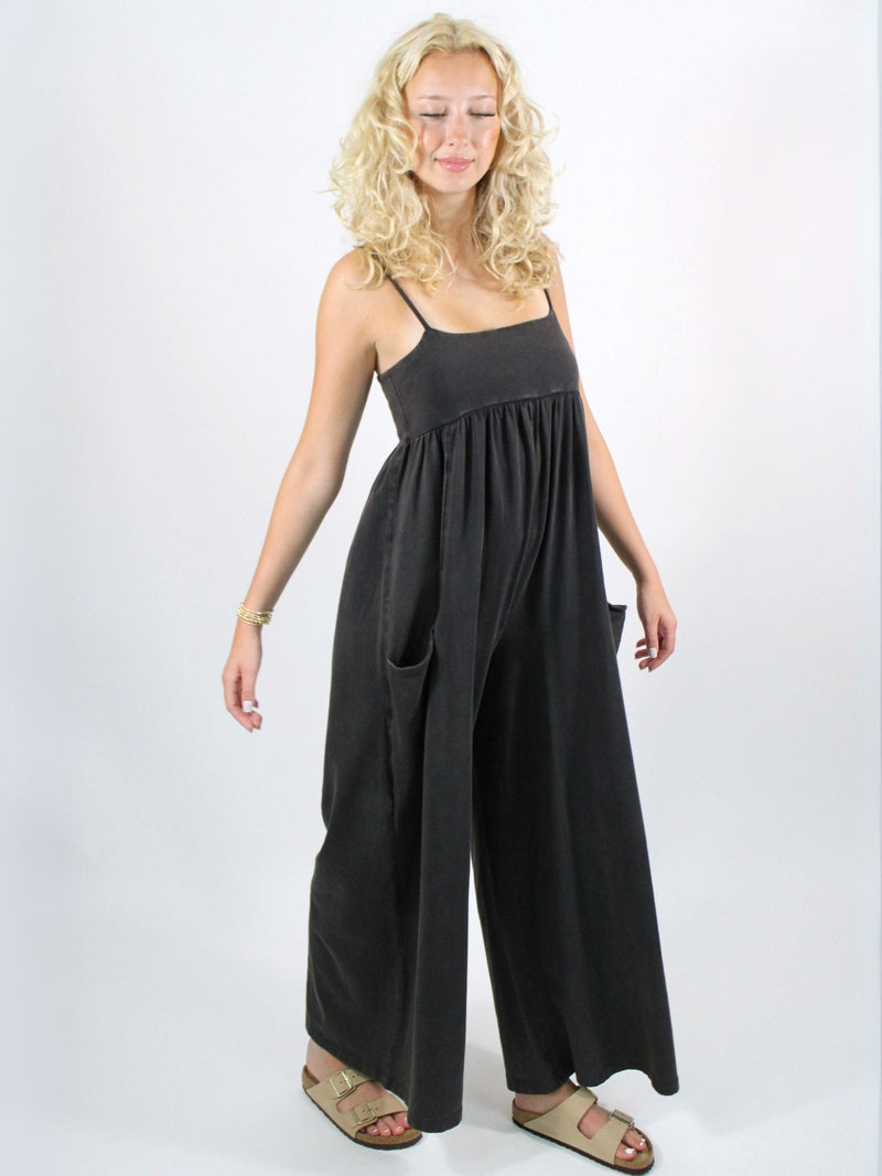 Woman wearing a black dress with wide-leg pants on a white background