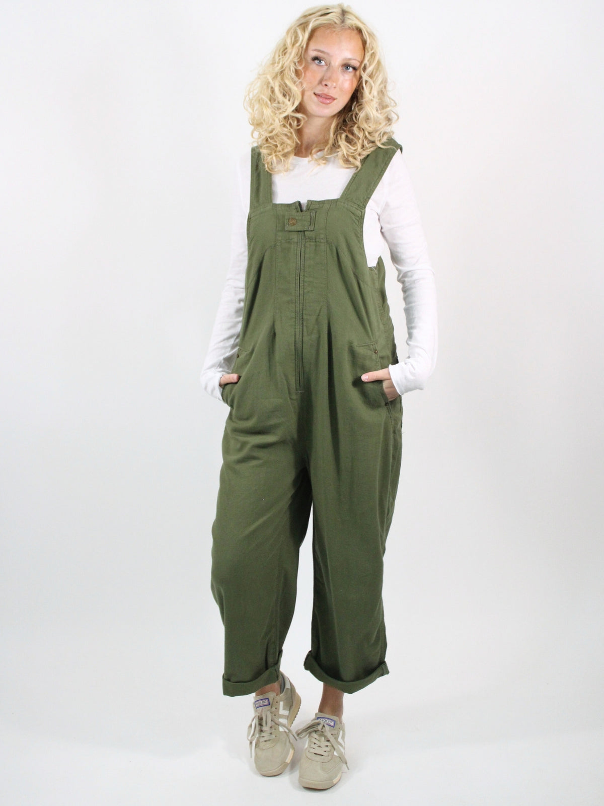 Woman wearing green overalls on a white background