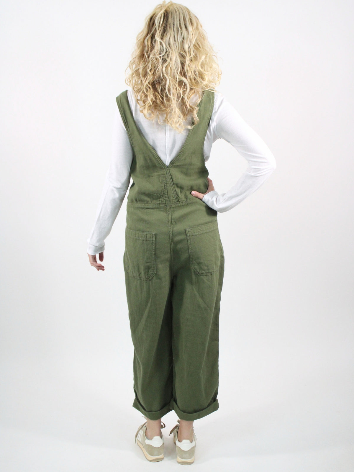 Person wearing green overalls on a white background