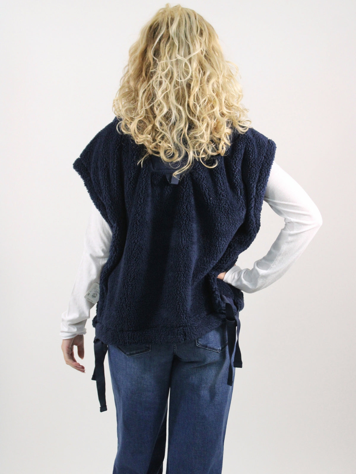 Person wearing a navy blue vest on a white background