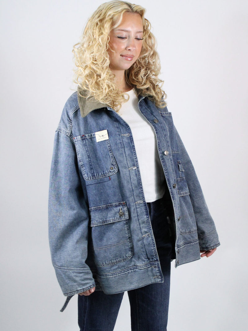 Woman wearing a blue denim jacket on a plain background