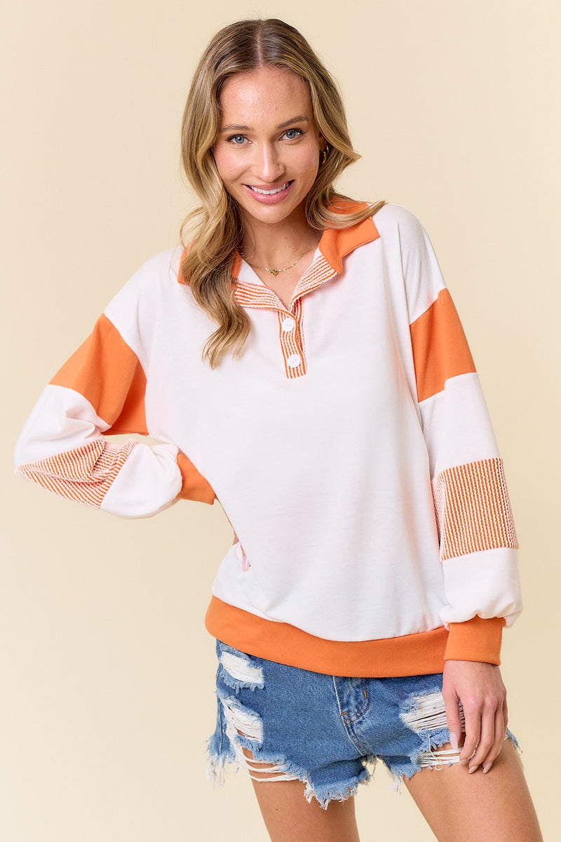 orange and white button collar sweatshirt on model 