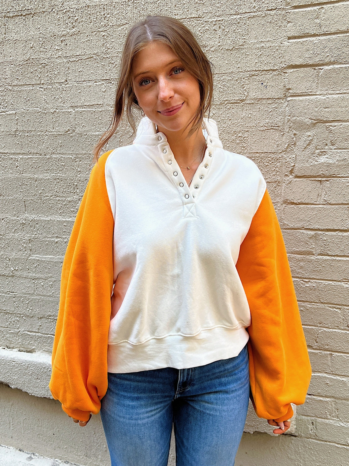 orange and white colorblock sweatshirt with snap button collar in orange and white front detail cover 