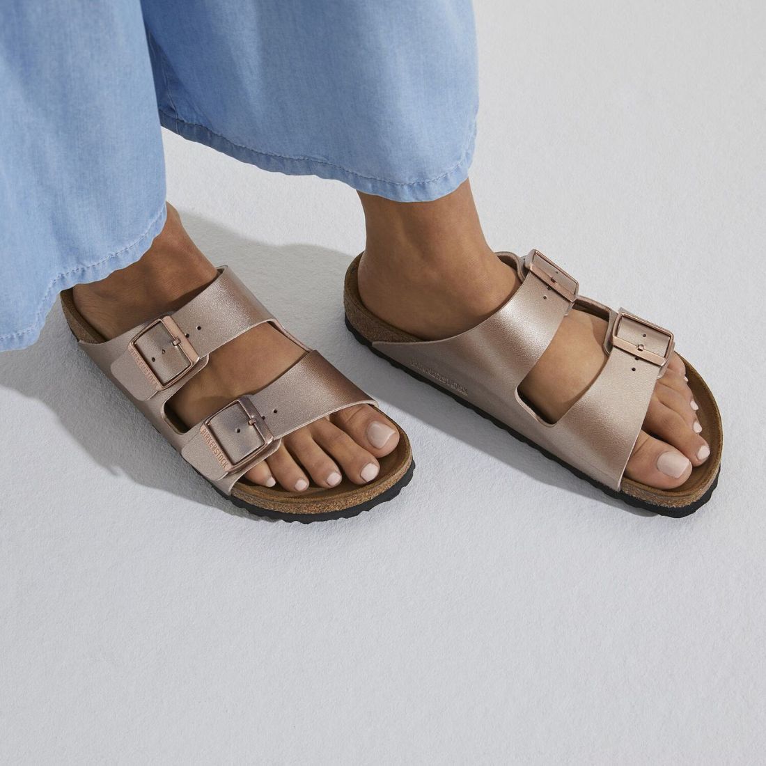 shop sandals for spring at bliss knoxville  close up of model feet in copper metallic birkenstock arizona sandals